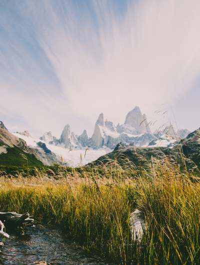 Majestic mountain with grassy foreground and expansive sky.