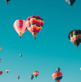 Colorful hot air balloons in clear blue sky