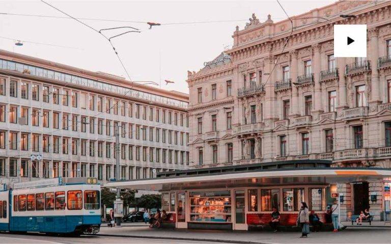 Tram passing historic European building facade.